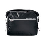 Close up view of a black Ballard Cargo Bag's front side. The top is rolled closed with carrying handle tight across the bag. The front features a silver reflective strip.