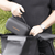 A Rad Portable Tire Inflator carrying case is being held by the handle and placed into a black pannier bag on an ebike. 
