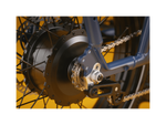 Detailed shot of a blue ebike with a black motor and silver bike chain.